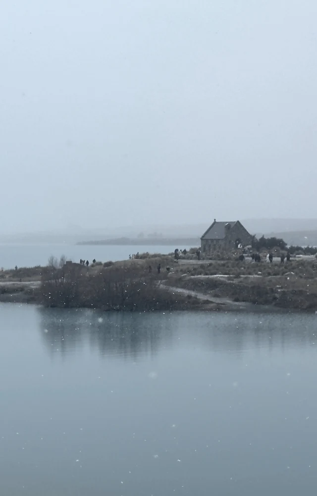 薄雾中的湖岸建筑和安静的蓝灰色湖水