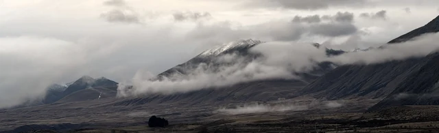 低云环绕雪山山脊的宽幅景色